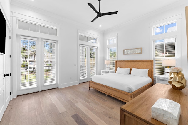 bedroom with multiple windows, light wood-type flooring, and access to exterior