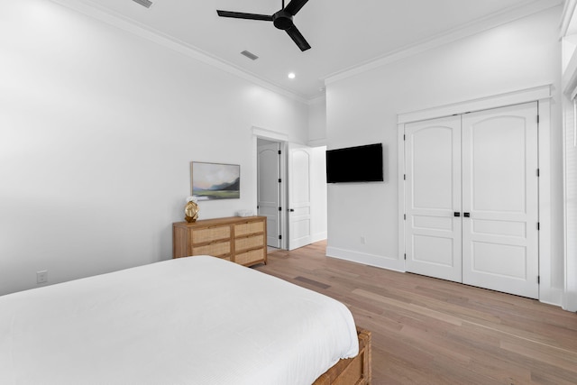 bedroom with crown molding, a closet, ceiling fan, and light wood-type flooring