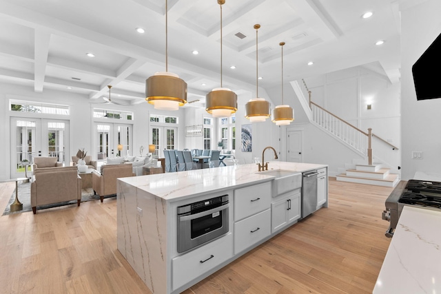 kitchen featuring french doors, light hardwood / wood-style flooring, hanging light fixtures, and light stone countertops