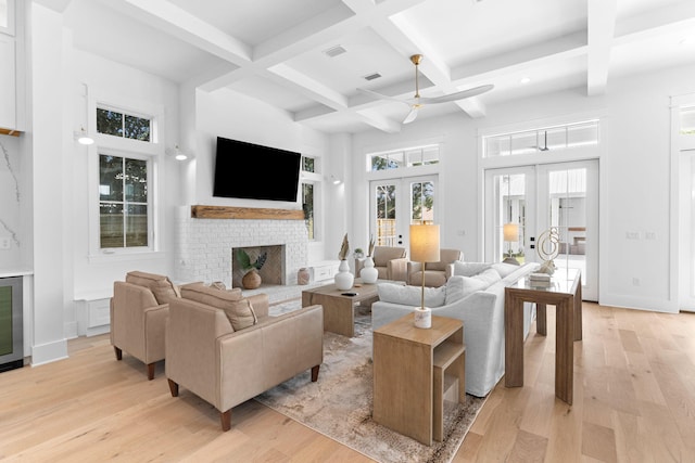 living room with french doors, light hardwood / wood-style floors, and coffered ceiling