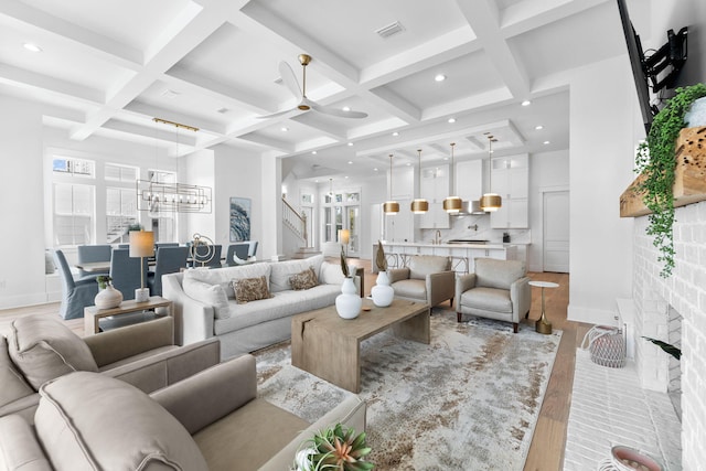 living room with beamed ceiling, light wood-type flooring, ceiling fan, and coffered ceiling