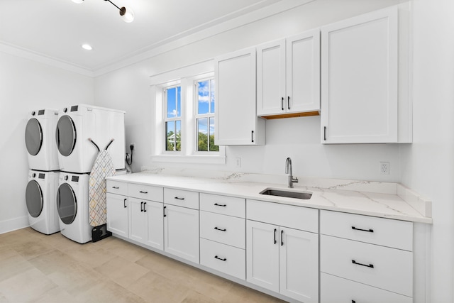 laundry room featuring cabinets, crown molding, stacked washer and dryer, sink, and light tile floors