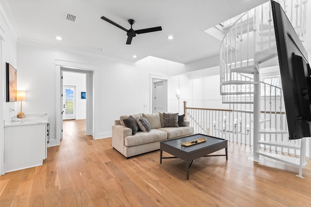 living room featuring ceiling fan, light hardwood / wood-style floors, and ornamental molding