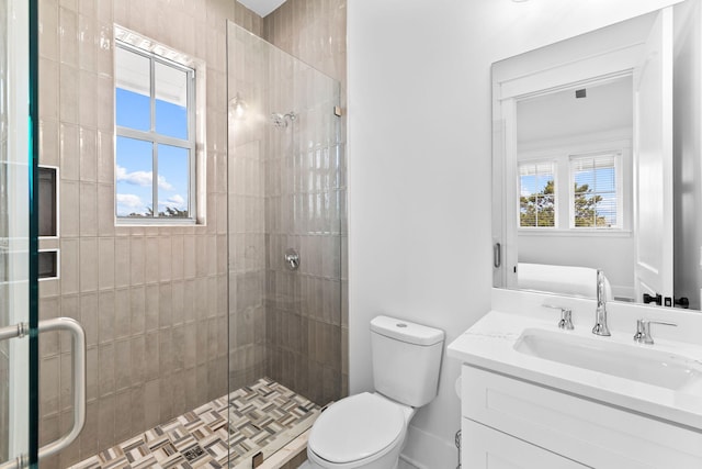 bathroom featuring large vanity, a shower with shower door, and toilet