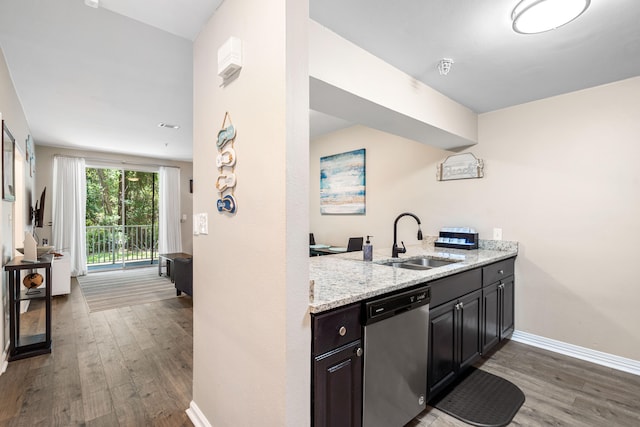 kitchen with light stone counters, sink, dark hardwood / wood-style flooring, and stainless steel dishwasher