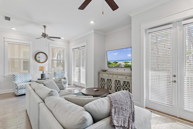 living room with ceiling fan, crown molding, and light wood-type flooring