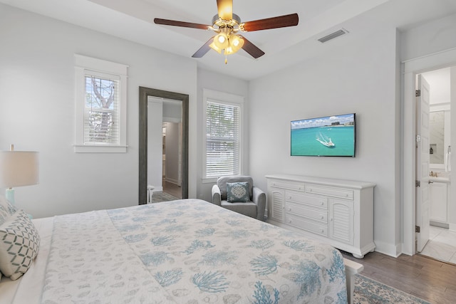 bedroom featuring hardwood / wood-style floors, connected bathroom, and ceiling fan