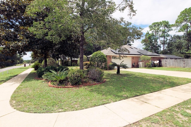 obstructed view of property featuring a garage, a front yard, central AC unit, and solar panels