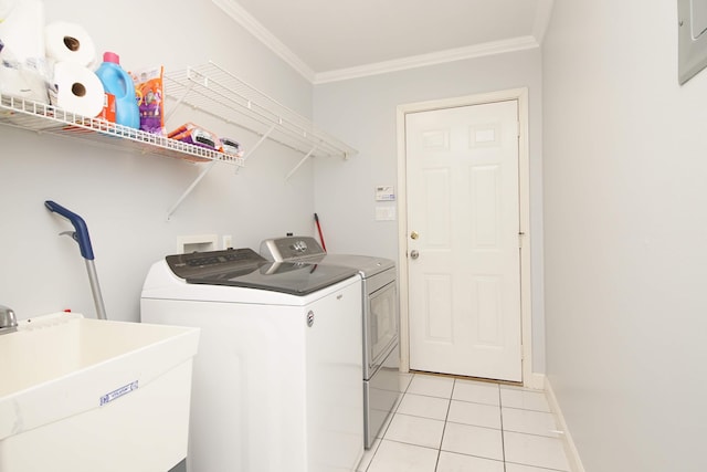 washroom with light tile patterned flooring, washing machine and dryer, ornamental molding, and sink