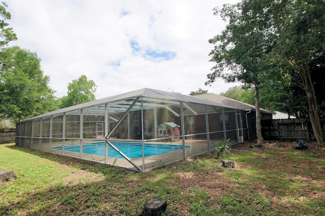 view of swimming pool featuring glass enclosure