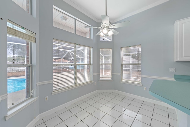 unfurnished dining area with light tile patterned floors, ornamental molding, and ceiling fan