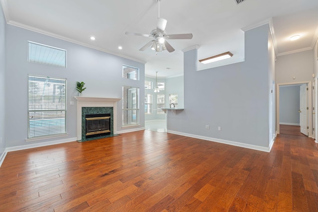 unfurnished living room featuring hardwood / wood-style flooring, a premium fireplace, ceiling fan, and crown molding