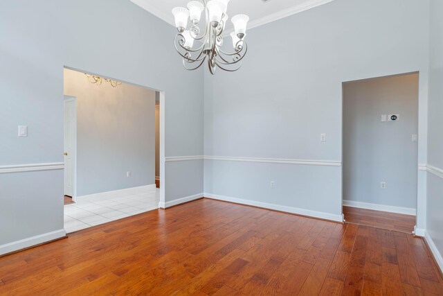 spare room with ornamental molding, light hardwood / wood-style flooring, and a notable chandelier