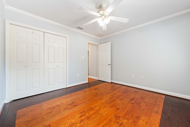 unfurnished bedroom with hardwood / wood-style flooring, ornamental molding, ceiling fan, and a closet