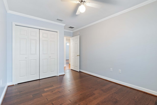 unfurnished bedroom featuring a closet, ornamental molding, and dark hardwood / wood-style floors