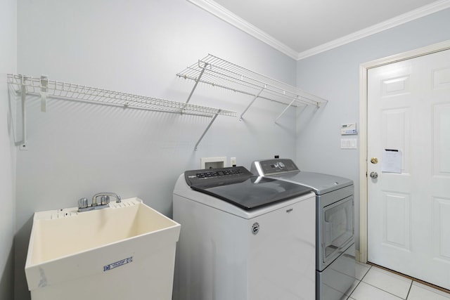 laundry room featuring sink, crown molding, independent washer and dryer, and light tile patterned floors