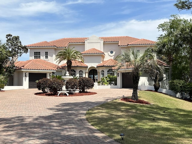 mediterranean / spanish home featuring a front yard and a garage