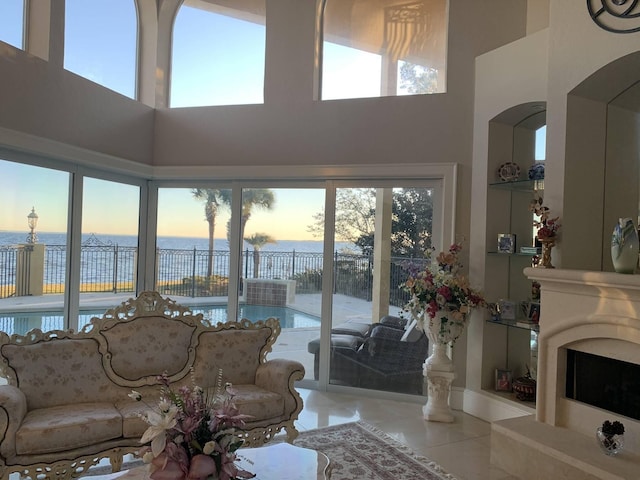 living room featuring a water view and a towering ceiling