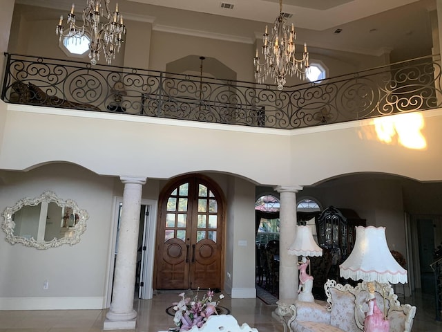 foyer entrance with ornate columns, a high ceiling, and french doors