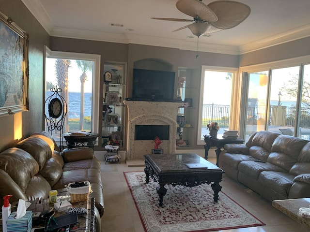 living room featuring plenty of natural light, ceiling fan, crown molding, and a premium fireplace