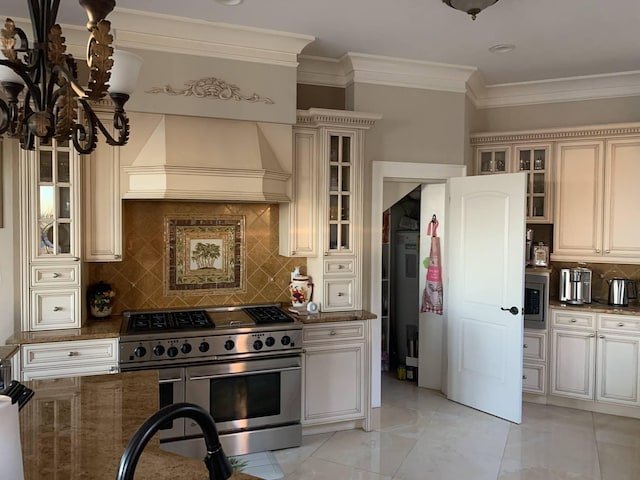 kitchen featuring tasteful backsplash, premium range hood, dark stone counters, stainless steel appliances, and crown molding