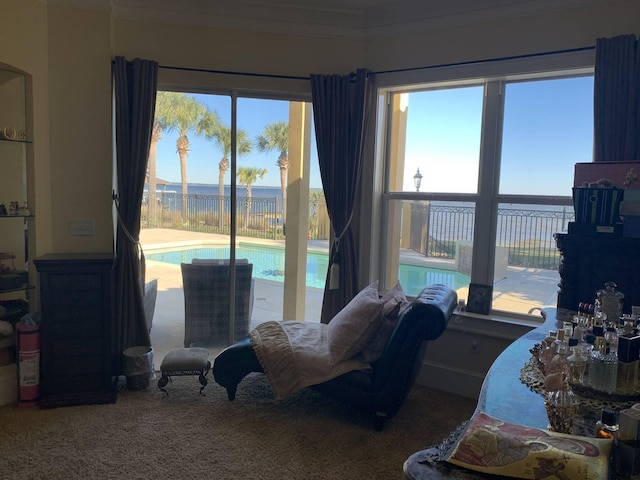 sitting room featuring carpet, a water view, and crown molding