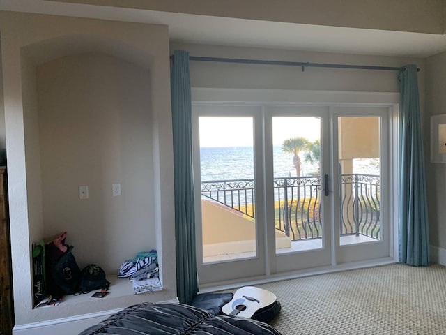 entryway with carpet and a water view