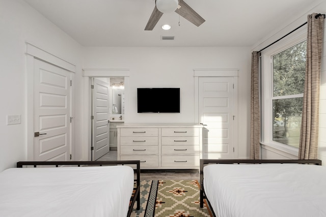 bedroom featuring ceiling fan, dark hardwood / wood-style flooring, and connected bathroom