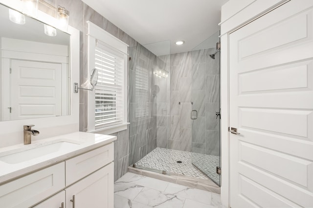 bathroom with a shower with door, tile floors, and large vanity