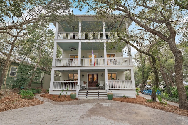 view of front facade with ceiling fan, a porch, and a balcony