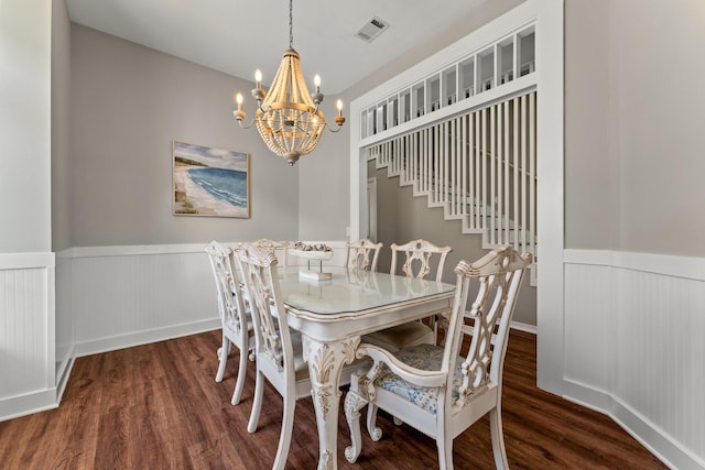 dining area with dark hardwood / wood-style floors and an inviting chandelier