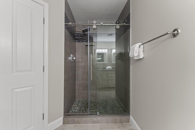 bathroom with a shower with shower door and tile flooring