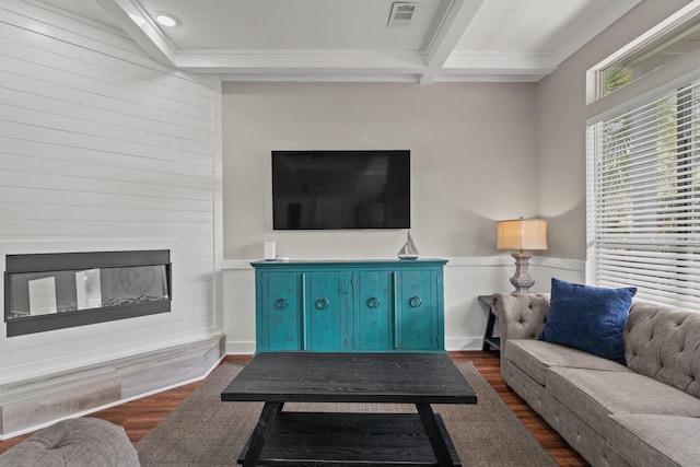 living room featuring beam ceiling, dark wood-type flooring, and a large fireplace