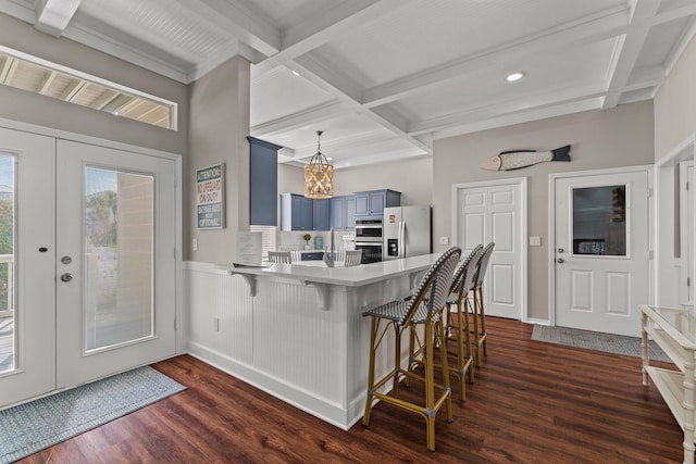 kitchen featuring kitchen peninsula, a kitchen bar, stainless steel appliances, dark hardwood / wood-style floors, and coffered ceiling