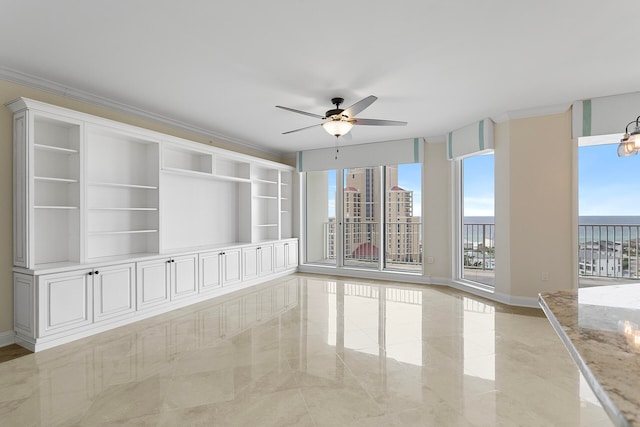 spare room featuring ceiling fan with notable chandelier, built in features, a water view, and ornamental molding