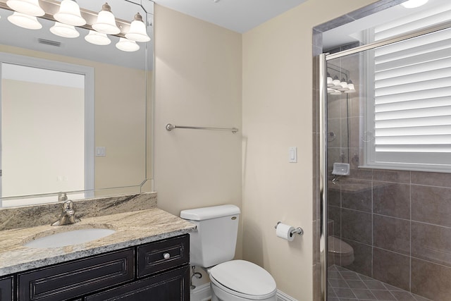 bathroom featuring vanity, toilet, and a shower with door