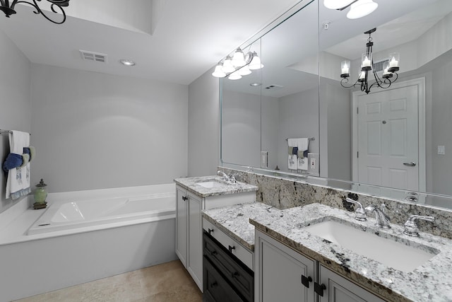 bathroom with vanity, a tub, and a notable chandelier