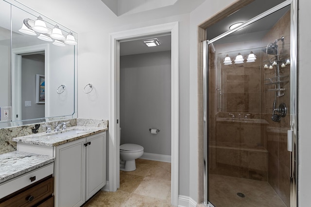 bathroom featuring an enclosed shower, vanity, and toilet