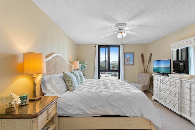 bedroom featuring carpet, a ceiling fan, and a textured ceiling