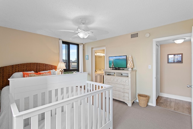 bedroom featuring a textured ceiling, carpet floors, a ceiling fan, visible vents, and baseboards