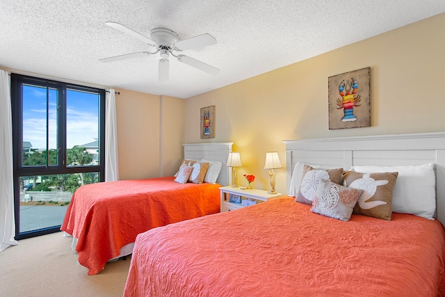 carpeted bedroom with a textured ceiling, ceiling fan, and expansive windows