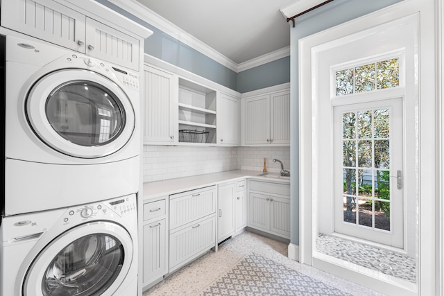 laundry area featuring cabinets, sink, and stacked washing maching and dryer