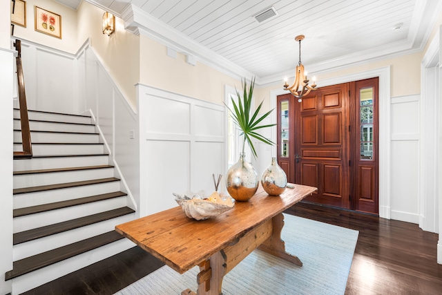 entryway with dark hardwood / wood-style flooring, an inviting chandelier, and ornamental molding