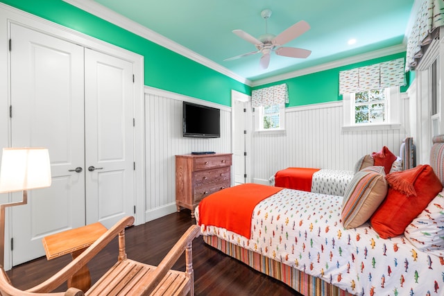 bedroom featuring a closet, ceiling fan, dark wood-type flooring, and crown molding