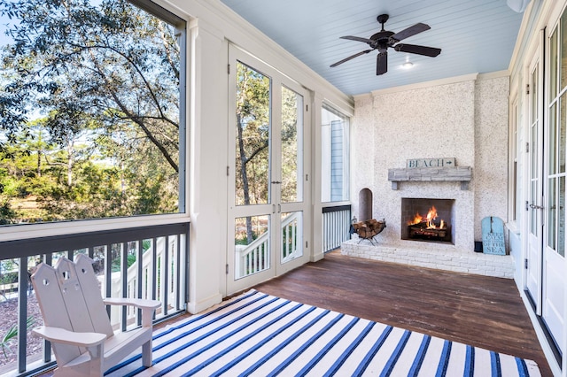 sunroom / solarium featuring a fireplace and ceiling fan