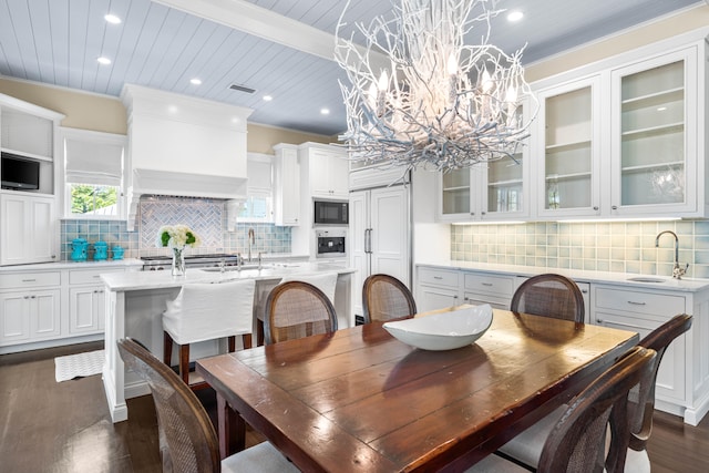 dining area featuring dark hardwood / wood-style floors, sink, crown molding, and a chandelier