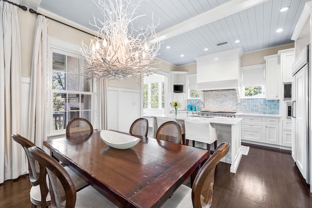 dining space with dark hardwood / wood-style floors, an inviting chandelier, plenty of natural light, and ornamental molding