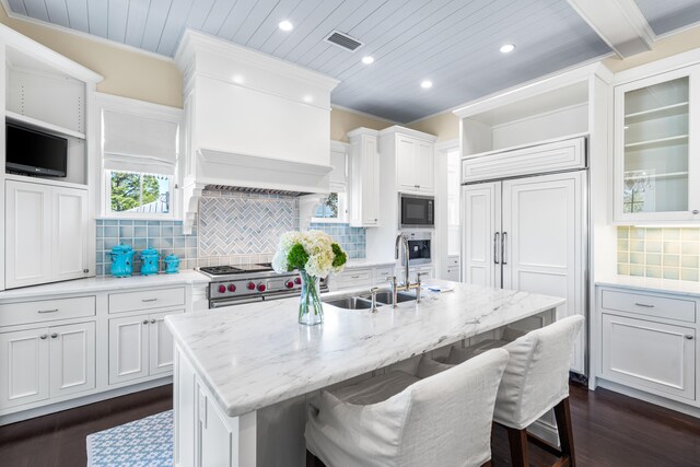 kitchen featuring white cabinetry, tasteful backsplash, built in appliances, and dark hardwood / wood-style floors