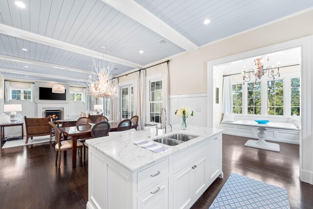 kitchen featuring beamed ceiling, sink, dark hardwood / wood-style floors, and an inviting chandelier