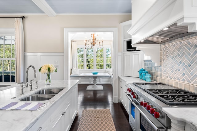 kitchen featuring premium range hood, white cabinets, double oven range, a notable chandelier, and tasteful backsplash